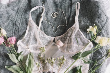 Mutlu Kadınlar Günü. Şık bir parfüm şişesi, modern mücevherler ve üzerinde bahar çiçekleri olan dantel iç çamaşırları. Yumuşak ve modaya uygun kadınsı imaj. Kadın esasları, parfüm