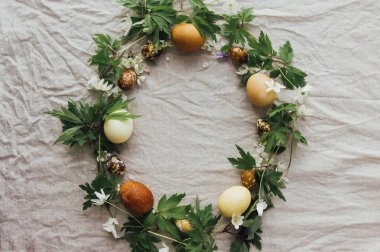 Mutlu Paskalyalar! Paskalya yumurtaları ve bahar çiçekleri kırsal çarşafların üzerinde, düzlük ve yazı için yer var. Doğal boya ve çiçeklerle süslenmiş estetik paskalya yumurtaları.