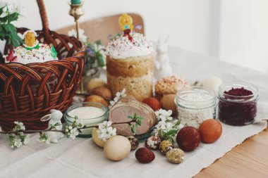 Geleneksel Paskalya yemeği, ev yapımı Paskalya ekmeği, şık paskalya yumurtaları ve çarşaf peçetesinde açan bahar çiçekleri. Mutlu Paskalyalar! Şenlikli kahvaltı.