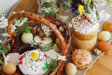 Geleneksel Paskalya yemeği, ev yapımı Paskalya ekmeği, şık paskalya yumurtaları ve çarşaf peçetesinde açan bahar çiçekleri. Mutlu Paskalyalar! Şenlikli kahvaltı.