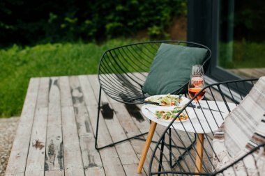 Lezzetli ev yapımı pizza ve aperol içeceği modern masadaki ahşap terasta, iki kişilik akşam yemeği. Lezzetli bir akşam yemeği ve dışarıda kutlama için kokteyller. Yaz tatili ve tatil yeri.