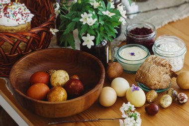 Şık paskalya yumurtaları, ev yapımı Paskalya ekmeği, lezzetli geleneksel Paskalya yemekleri ve kırsal masada açan bahar çiçekleri. Mutlu Paskalyalar! Şenlikli kahvaltı.