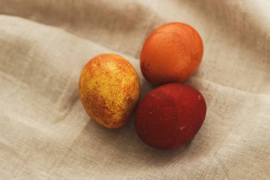 Kırsal keten kumaş arka planda modern paskalya yumurtaları ve metin için yer var. Mutlu Paskalyalar! Gri tekstil üzerine kırmızı renkte doğal boyanmış yumurta. Estetik