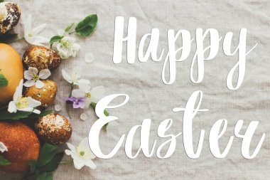 Mutlu Paskalya tebrik kartları. Modern sarı paskalya yumurtalarına el yazısıyla Mutlu Paskalya yazıları, bahar çiçekleri ve kır kumaşında çiçekler. Güzel kartpostallar, mevsimler selamlar