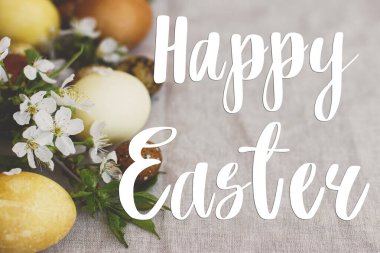 Mutlu Paskalya tebrik kartları. Paskalya 'da modern sarı paskalya yumurtalarında, bahar çiçekleri ve çarşaf bezinde el yazısıyla mutlu yazılar. Güzel kartpostallar, mevsimler selamlar