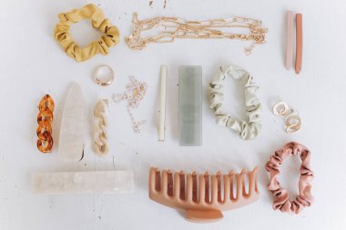 Modern yaz aksesuarları. Altın mücevherler, saç tokaları ve saç bantları, beyaz masa manzaralı tokalar. Kadınsı ihtiyaçlar. Boho renkli aksesuarlar