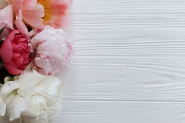 Fotokopi alanı olan beyaz ahşap üzerinde güzel, yumuşak bir kenar. Güzel pembe ve beyaz şakayıklar kır ağaçlarında çiçek açarlar. Çiçekli tebrik kartı. Anneler Günün kutlu olsun.