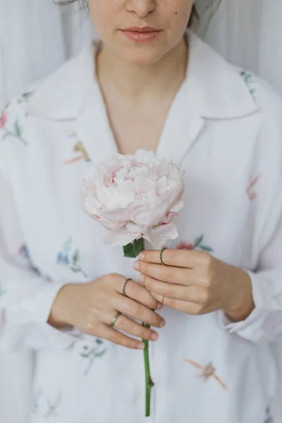 ピンクの牡丹を持つ美しいスタイリッシュな女性 手に大きな牡丹の花を優しく保持Boho花シャツの若い女性 官能的なソフトイメージ 春の美学 — ストック写真