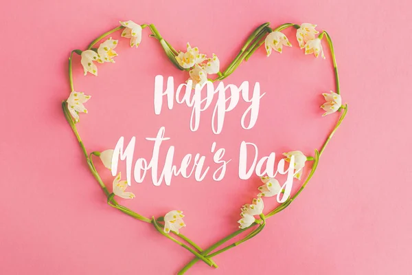 幸せな母親の日 幸せな母の日のテキストと花の心のフラットピンクの紙に横たわっていた スタイリッシュな花のグリーティングカード ピンクの春の花で作られた心に手書きのレタリング 母の日 — ストック写真