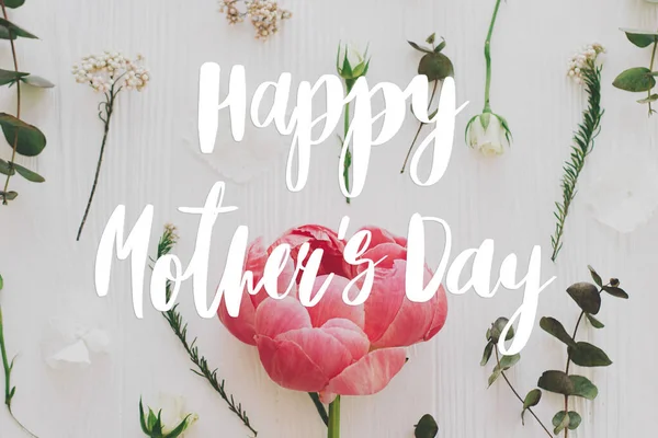 幸せな母親の日 幸せな母の日のテキストと牡丹 バラとユーカリの枝と白い木のフラットレイアウト上の花の組成 スタイリッシュな花のグリーティングカード 手書き文字 母の日 — ストック写真