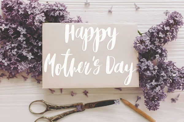 幸せな母親の日 カードとライラックの花 ヴィンテージはさみ 白い素朴な木の上の景色に鉛筆で幸せな母親の日のテキスト スタイリッシュな花のグリーティングカード 手書き文字 母の日 — ストック写真