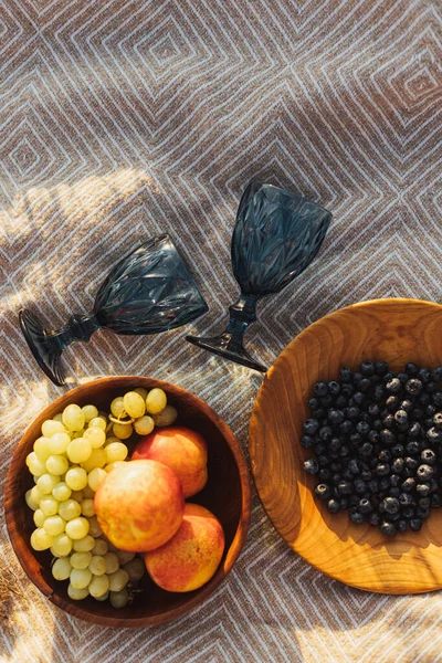 Frische Köstliche Früchte Holzteller Und Blaue Weingläser Auf Gelbem Karo — Stockfoto