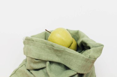 Beyaz arka planda pamuk torbada taze elmalar. Sıfır atık. Yeniden kullanılabilir yeşil torbada organik meyveler. Eko dostu plastik market teslimatı. Sürdürülebilir yaşam tarzı