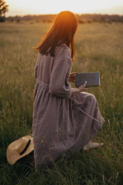 Keten Elbiseli Güzel Bir Kadın Elinde Kitapla Gün Batımında Çayırda — Stok fotoğraf