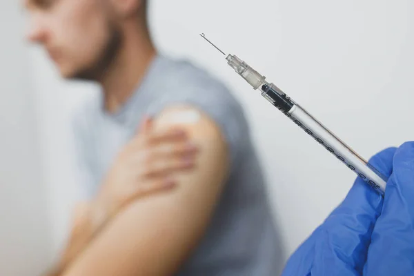 Рука Медичній Рукавичці Тримає Шприц Вакциною Covid Задньому Плані Людини — стокове фото