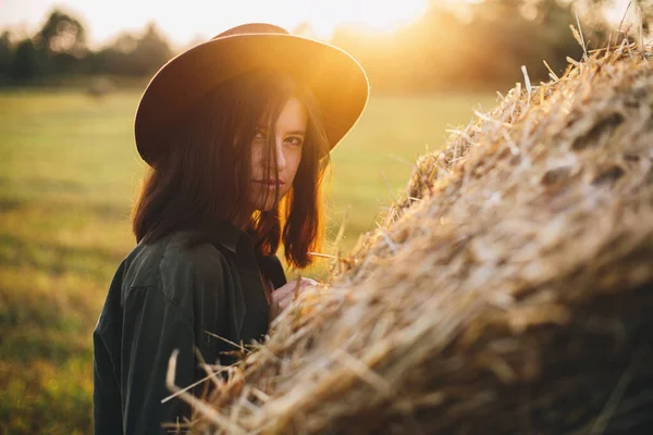 Schöne Stilvolle Frau Mit Hut Posiert Auf Heuhaufen Sonnenuntergang Sommerfeld — Stockfoto