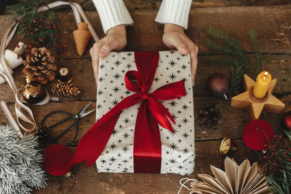 Mãos Segurando Presente Natal Elegante Envolto Papel Mesa Madeira Rústica — Fotografia de Stock