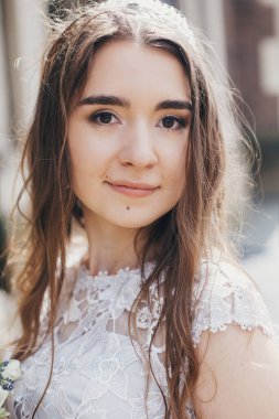 Avrupa 'nın güneşli caddesinde şık bir elbise içinde poz veren güzel gelinin portresi. Güneşli ışıkta şık bir gelinlik içinde şehvetli bir gelin. Provence düğünü