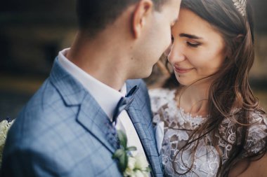 Eski kilisenin arka planına sarılmış şık gelin ve damadın portreleri. Romantik bir an. Provence düğünü. Güzel, şehvetli bir düğün çifti Avrupa şehrinde nazikçe sarılıyor.