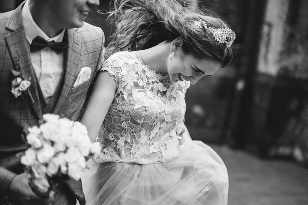 雨の中で古い教会の背景にスタイリッシュな幸せな花嫁と新郎歩くと 閉じる プロバンス結婚式 美しい感情的な結婚式のカップル笑顔 ロマンチックな瞬間 黒と白のイメージ — ストック写真