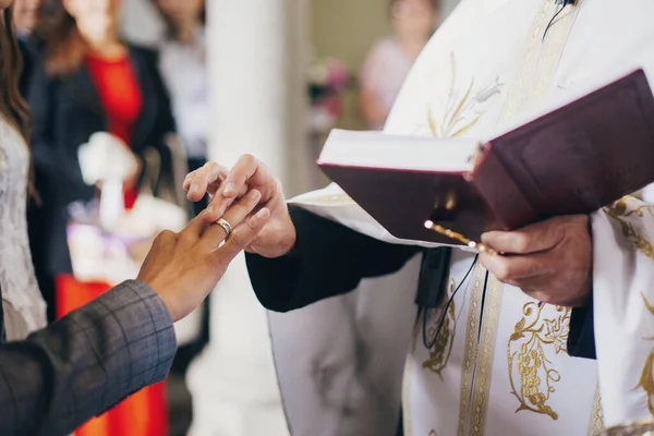 신부는 교회에서 결혼중에 신랑의 손가락에 깃털이 결혼반지를 대성당에서의 결혼식 신부를 — 스톡 사진