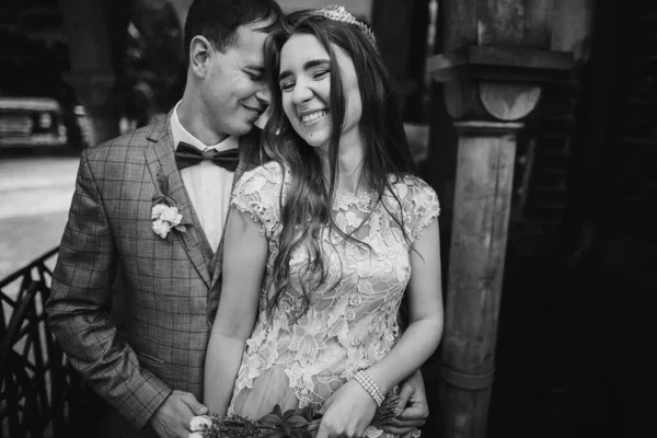 Κομψό Ευτυχισμένη Νύφη Και Γαμπρός Χαμογελά Και Αγκαλιάζει Στο Παρασκήνιο — Φωτογραφία Αρχείου