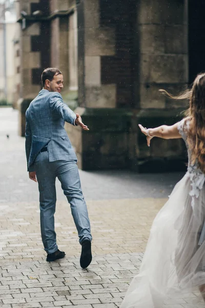 Noiva Elegante Noivo Correndo Fundo Igreja Velha Rua Chuvosa Casamento — Fotografia de Stock