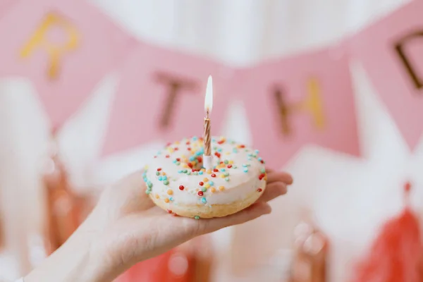 Gogoasa Delicioasa Ziua Nastere Lumanare Mana Fundalul Ghirlandei Roz Decoratiuni — Fotografie, imagine de stoc