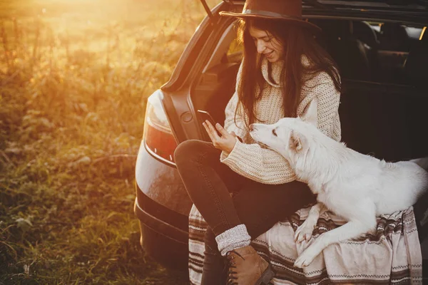 Elegante Mujer Hipster Sombrero Suéter Sosteniendo Teléfono Sentado Con Perro —  Fotos de Stock