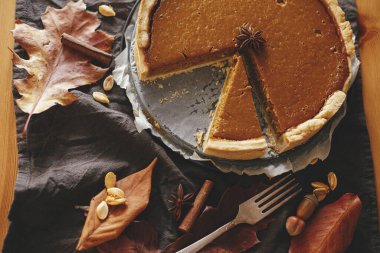 Mutlu Şükran Günleri Kağıt üzerinde parşömen kâğıdı üzerinde balkabağı turtası keten peçete, sonbahar yaprakları, anason, tarçın ve çatal bıçaklı. Ev yapımı kabaklı tart tarifi. Üst görünüm