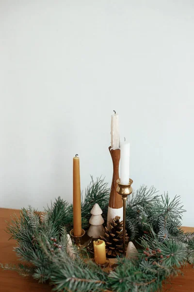 在节庆室的白色墙壁的背景上 用松果和装饰在木制桌子上的圣诞树装饰的圣诞花环装饰着时尚的蜡烛 圣诞节来了大气冬季假期 — 图库照片