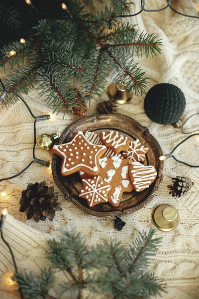 盘子里的圣诞姜饼 枞树枝条 装饰品以及舒适的针织背景上温暖的灯光 冬季的大气时间和Hgge家 圣诞快乐及节日快乐 — 图库照片