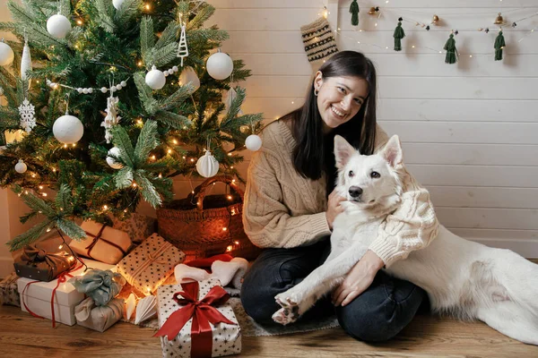 Stijlvolle Vrolijke Vrouw Zittend Knuffelende Schattige Hond Onder Kerstboom Met — Stockfoto