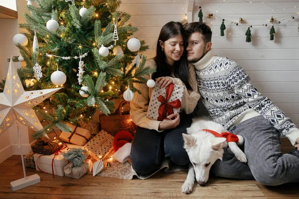 Elegante Pareja Con Lindo Perro Sosteniendo Regalo Navidad Con Lazo — Foto de Stock
