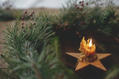 Noel yaklaşıyor. Eski ahşap arka planda Noel çelenginde yakan şık bir mum. Karamsar atmosfer zamanı. Mesaj için yer var. Mutlu Noeller ve mutlu tatiller!