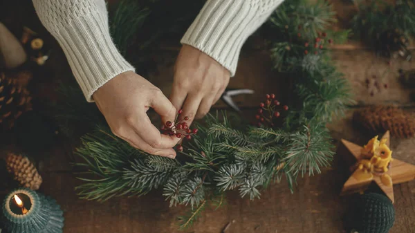 Fazendo Grinalda Natal Rústica Perto Mãos Mulher Segurando Bagas Vermelhas — Fotografia de Stock