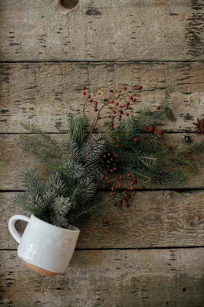 带有散落的云杉枝条 红色浆果 松果和茴香的时髦杯子躺在古朴的木制背景平面上 圣诞快乐 节日快乐 案文的篇幅 — 图库照片