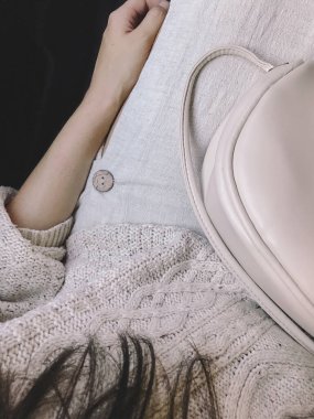 Üstten görünüşlü, şık bir kadın, en az bej kıyafetler. Yakın plan. Modern bej süveter, etek ve çanta giyen modaya uygun genç bir bayan. Estetik