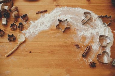 Noel kurabiyesi yapıyorum. Kaşık ve un, metal kurabiye keskisi, ahşap masa üzerindeki baharatlar. Sihirli kış ve tatil hazırlıkları. Noel bisküvisi tarifi. Yaratıcı yerleşim