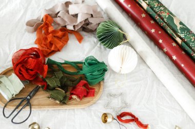 Noel ambalaj kağıdı, modern kağıt süslemeleri, kurdeleler, kırsal masada makas. Düz yatıyordu. Mutlu Noeller ve mutlu tatiller!