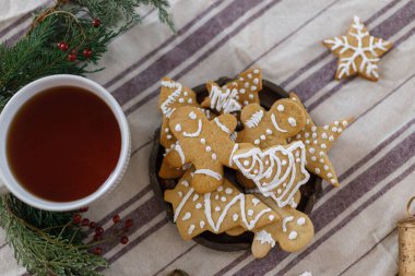 Noel kurabiyeleri, bir fincan sıcak çay, bayram masasının üzerinde köknar dalları. Mutlu Noeller! Sıcak kış zamanı