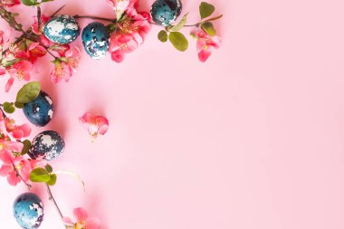 Mutlu Paskalyalar! Kırmızı çiçekli Paskalya yumurtaları pembe arka planda yatıyordu. Stil yay şablonu ve metin için boşluk. Paskalya tebrik kartı ya da afişi