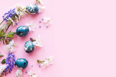 Mutlu Paskalyalar! Kiraz çiçekli Paskalya yumurtaları pembe arka planda yatıyordu. Stil yay şablonu ve metin için boşluk. Paskalya tebrik kartı ya da afişi
