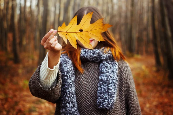 Girl holding yellow leaf — Stock Photo, Image