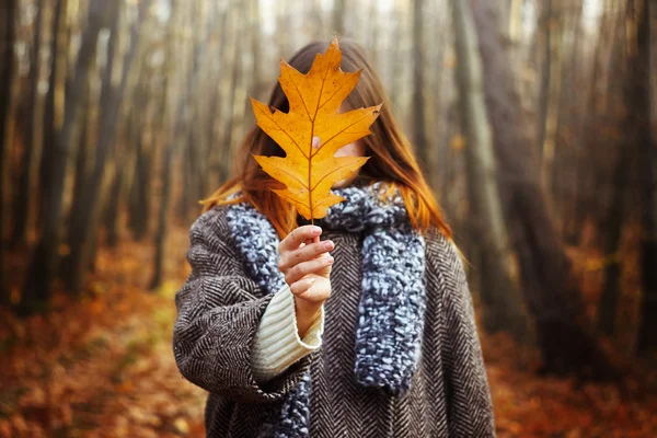 Girl holding yellow leaf — Stock Photo, Image