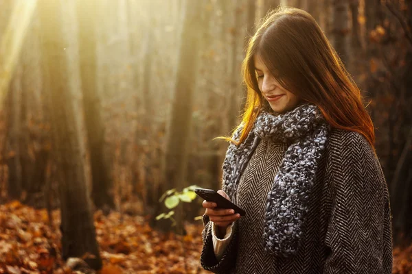 Brunette girl looking at the smartphone — Stock Photo, Image