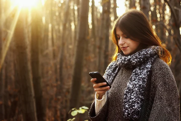 Brunette girl looking at the smartphone — Stock Photo, Image