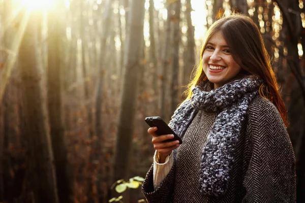 Brunette girl looking at the smartphone — Stock Photo, Image