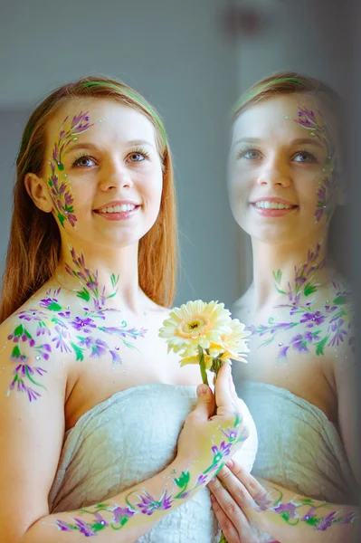 Girl with flower bodyart and sunflowers bouquet and wreath