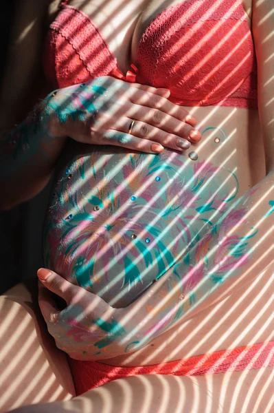 Giovane donna incinta con bodyart sulla pancia — Foto Stock